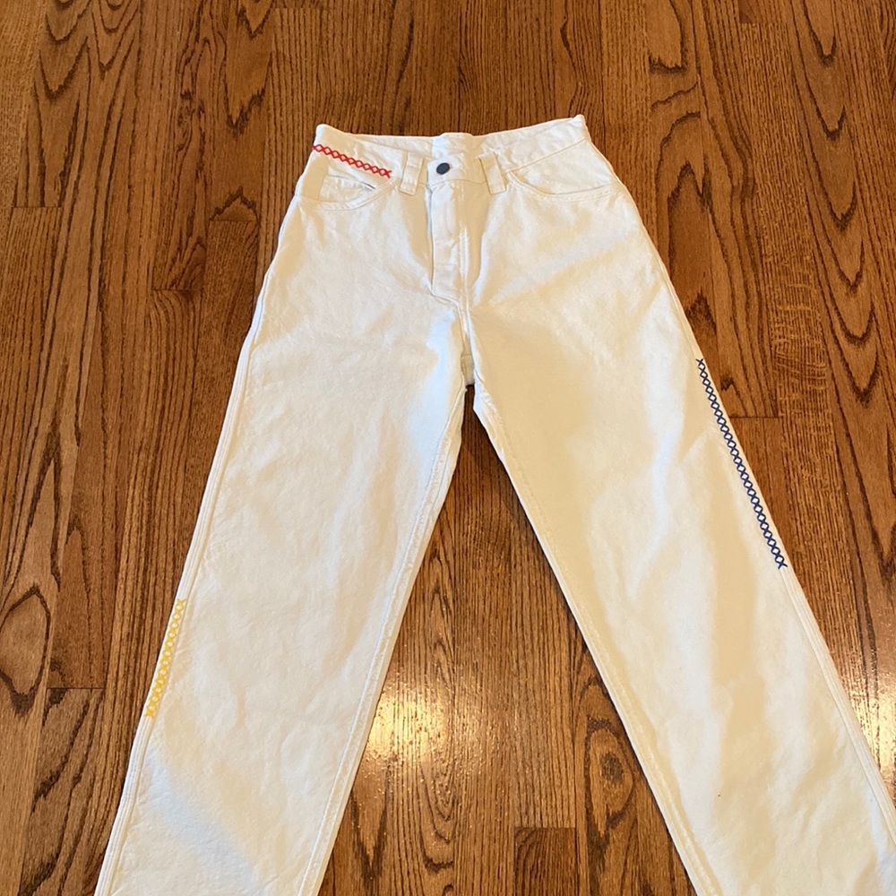 White Madhappy jeans with rainbow stitching on the sides
